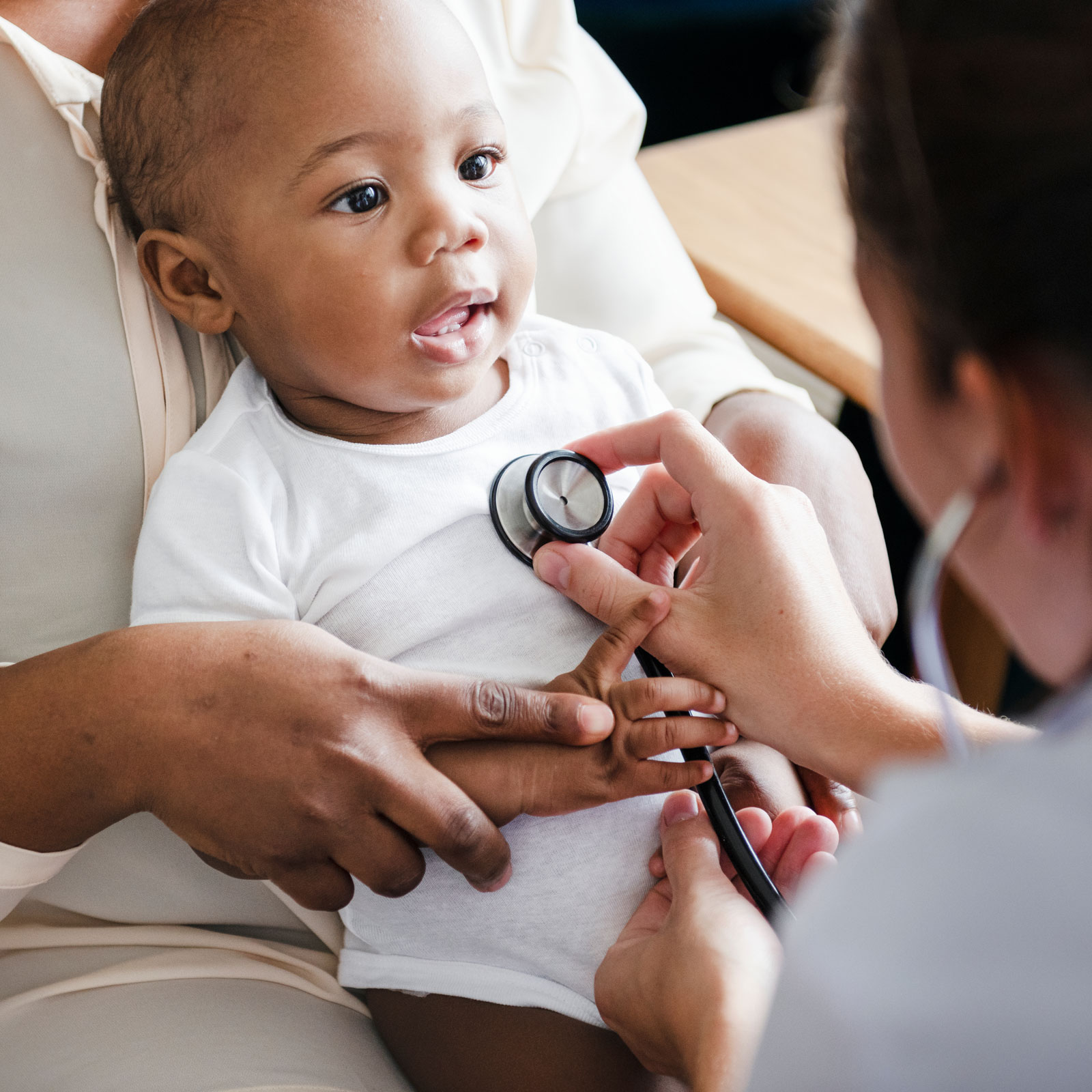 a pediatrician listens to a baby's heart using a stethoscope